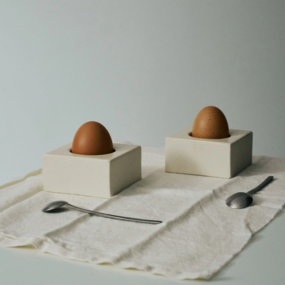 witten uovo eierdoppen, vierkant met afdruk van een ei met een ei er in op tafel