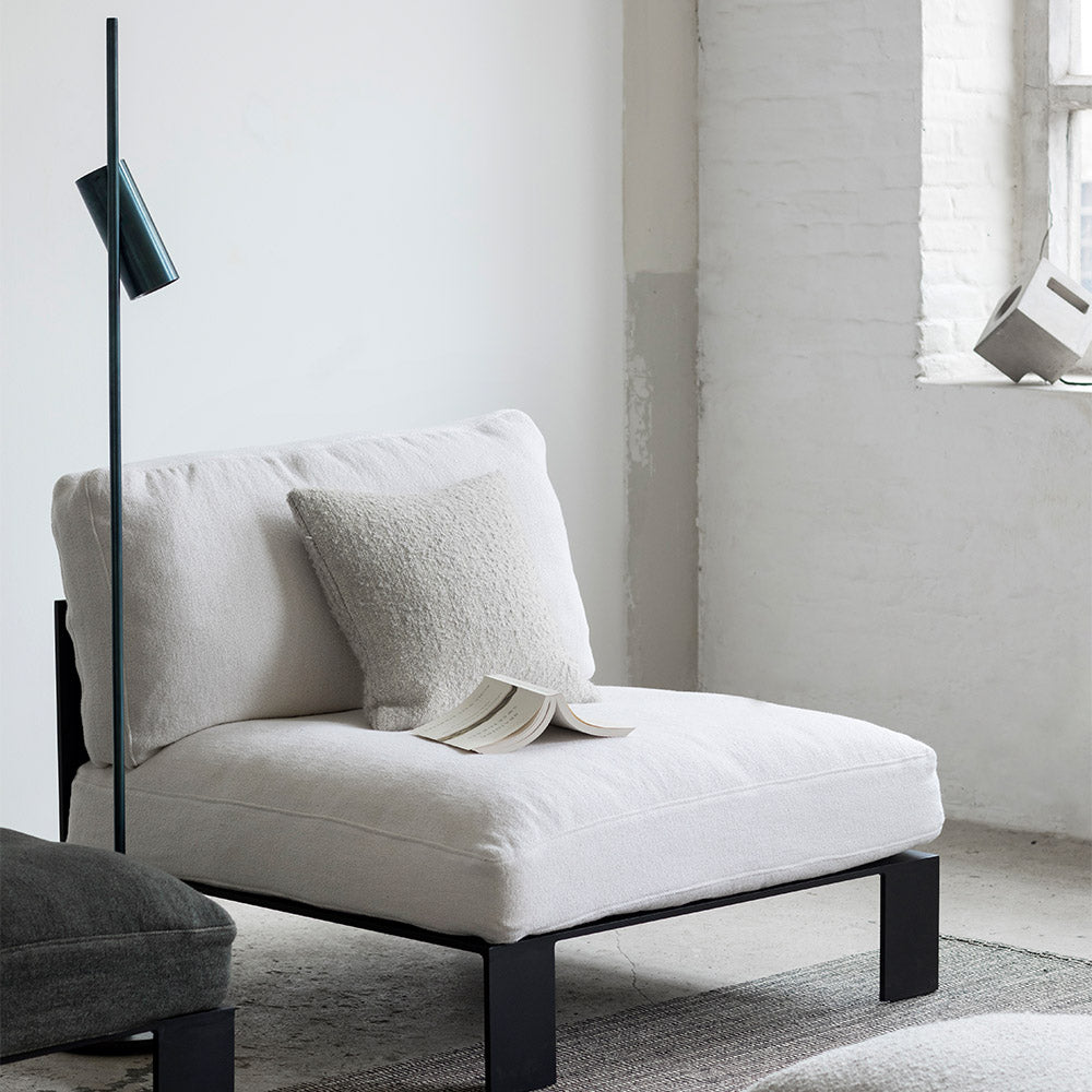 lange zwarte staande leeslamp of accentverlichting in combinatie met een stoel