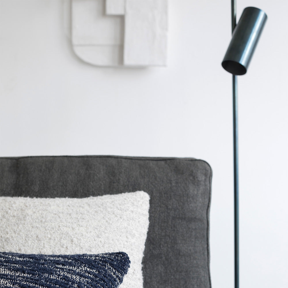 lange zwarte staande leeslamp of accentverlichting bij een bed in de slaapkamer