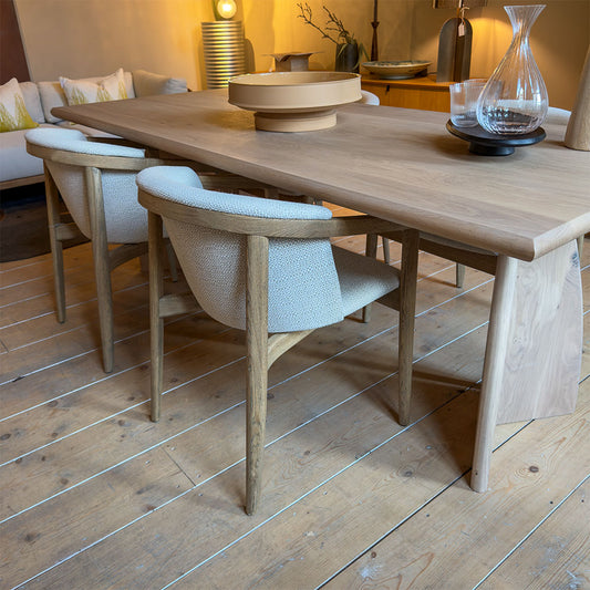rose stoel van eikenhout en stof met armleuning bij een houten tafel