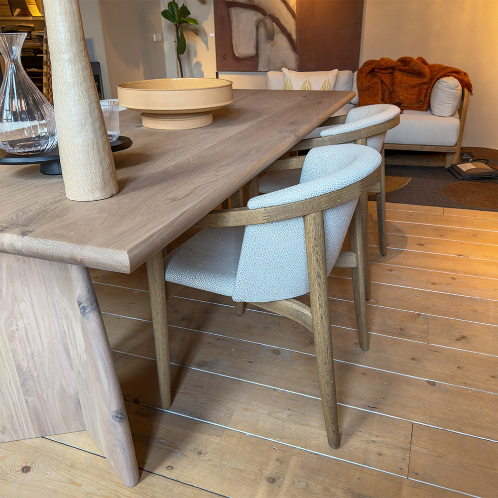 rose stoel van eikenhout en stof met armleuning bij een houten tafel