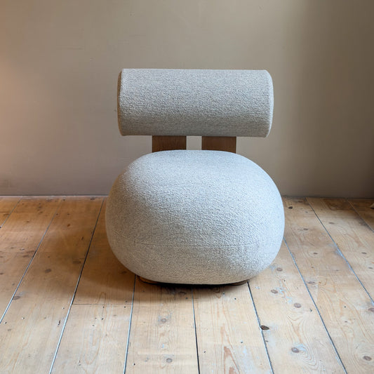 hippo lounge stoel met houten omlijning en met zachte rugleuning en bolle zitting voor een muur