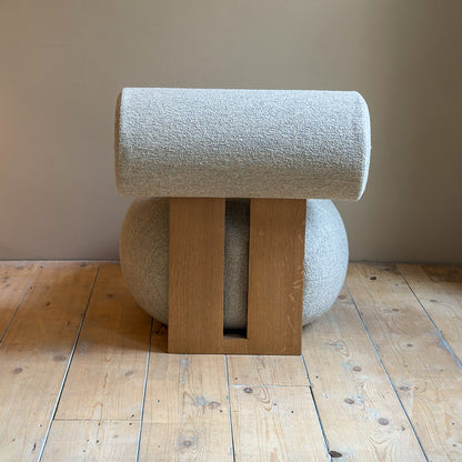 achterkant van hippo lounge stoel met houten omlijning en met zachte rugleuning en bolle zitting voor een muur